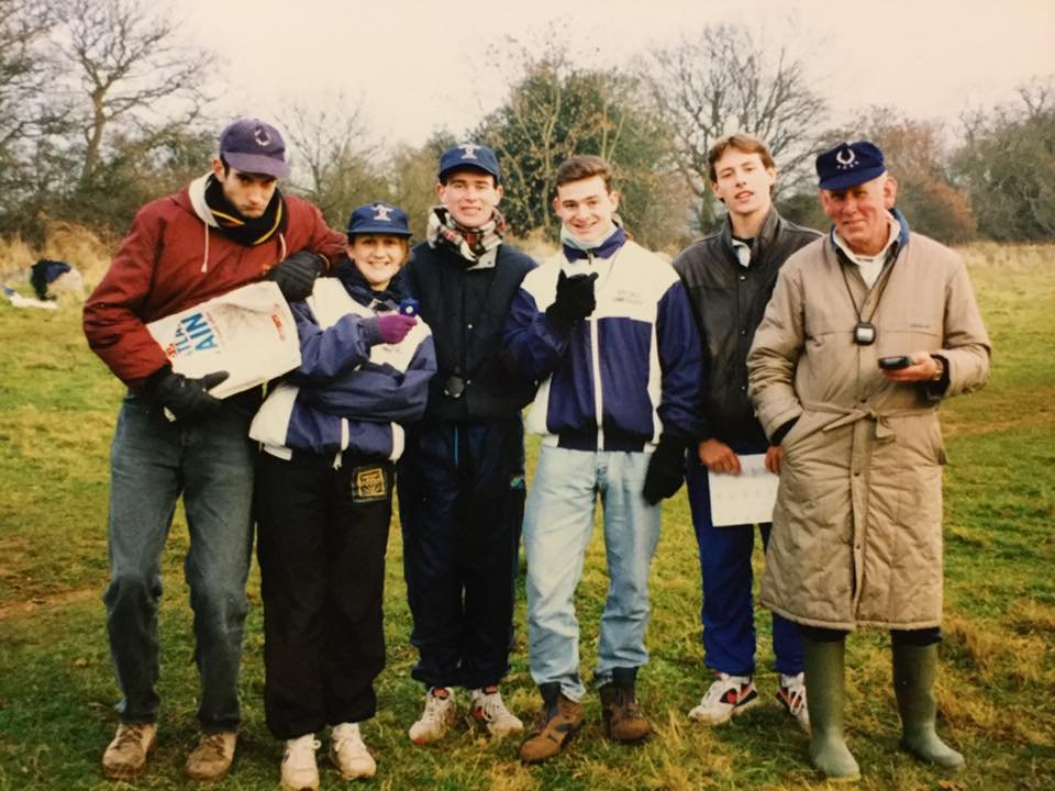 Runners and an official with a stopwatch at an earlier II–IVs, wrapped up in winter coats and caps